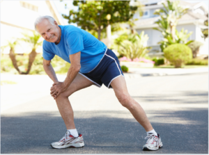Senior man stretching outdoors before a workout, wearing athletic gear – ideal exercise for one of the 5 exercises for seniors to lose belly fat