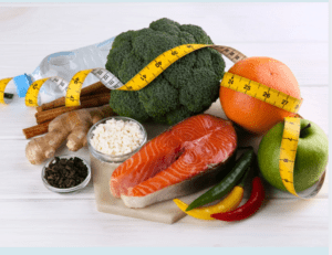  A selection of nutrient-rich foods including salmon, broccoli, fruits, ginger, and cottage cheese wrapped in a measuring tape—ideal components for the Metabolic Confusion Diet and sustainable weight loss.